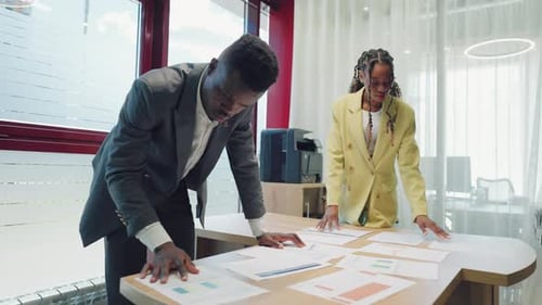 Two Businesspersons are Examining Documents in Office Black Man and Woman Lawyers