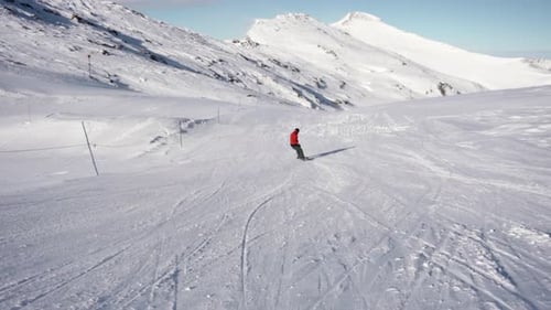 Snowboarder macht Kurven, Weitwinkelaufnahme in Zeitlupe