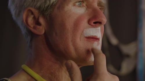 Close-Up of Face of Man Applying White Paint Creating Clowns Look