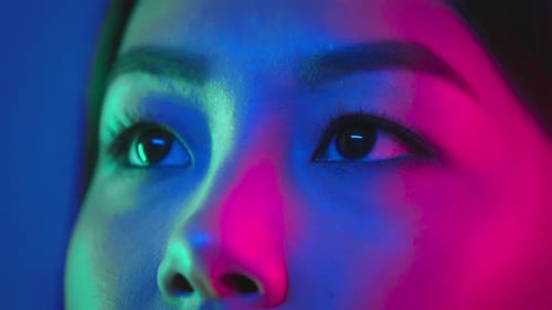 Young Woman in Neon Light Reflecting a Futuristic Atmosphere