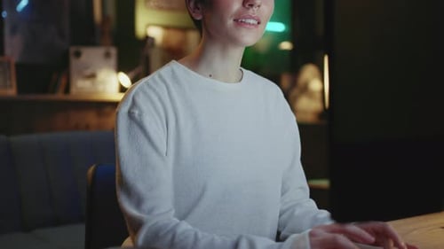 Young Adult Works on Computer in Home Interior at Night