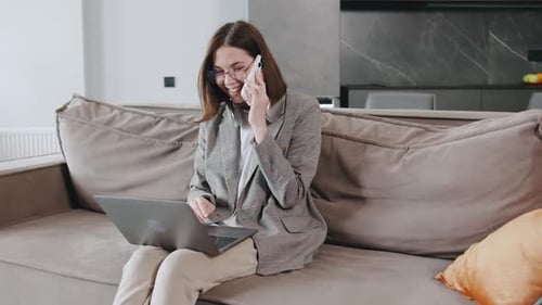 Woman Working at Home on Laptop and Phone
