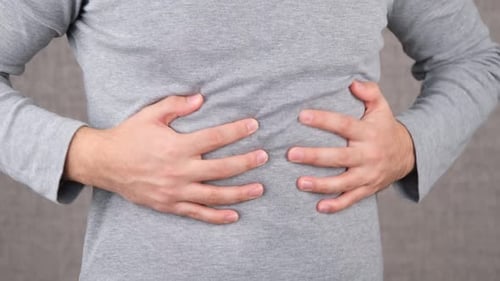 Adult Holding Stomach in Painful Abdominal Distress