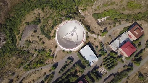 Downwards Rotating Aerial Shot of Mount Aragats Radio Optical Telescope's Herouni Mirror on a Sunny