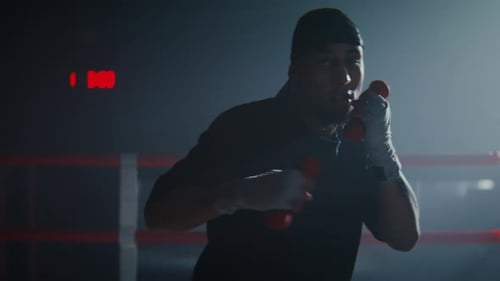 Boxer Shadow Boxing in a Dark Boxing Ring