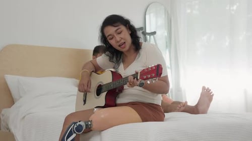 Woman Plays Guitar and Sings at Home