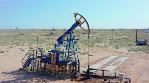 An Oil Pump Jack Works Tirelessly in the Middle of an Arid Desert