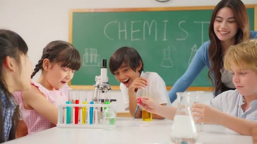 Adorable student learn with teacher in classroom at elementary school.