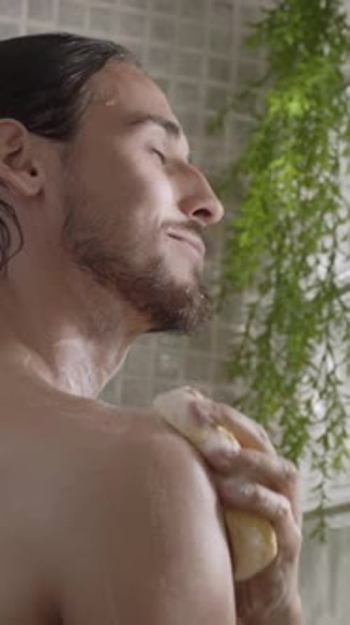 Young Man Scrubbing Shoulders in Shower