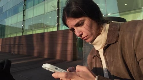 Woman Using Phone in Urban Setting During the Day