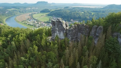 Majestic aerial view of rock formations above the Elbe River and dense forest in Saxon Switzerland,