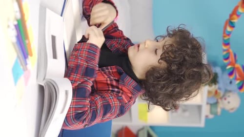 Vertical Video of Boy doing homework at his desk. Education concept.