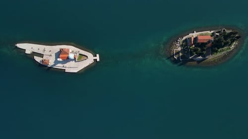 aerial top down view of Nossa Senhora das Rochas church and São Jorge Island surrounded by crystal c