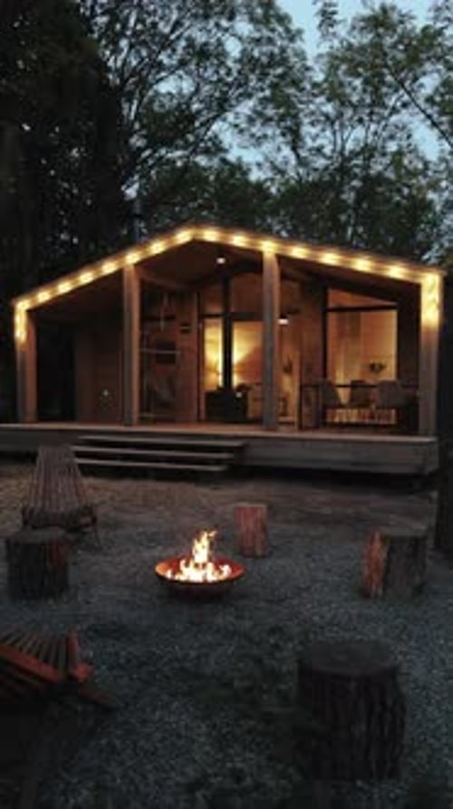 Cabin with Fire Pit in the Woods at Night