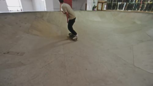 Skateboarder Riding Bowl at Indoor Skatepark