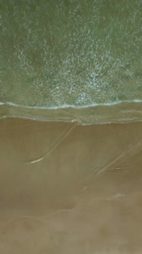 Sea waves breaking on sand beach