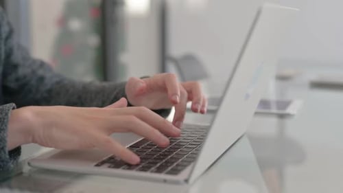 Hands Typing on a Laptop at a Desk