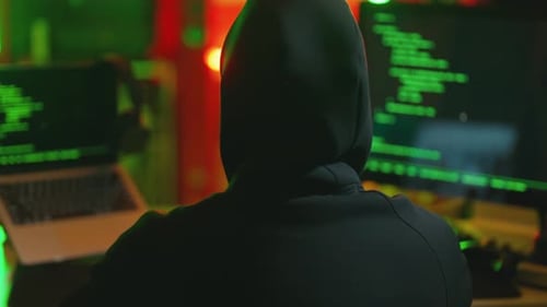 Hacker Writing Code Cracking Computer Man Programmer in Hoodie Cracks System Using Computer in Dark