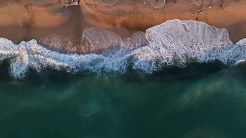 Cinematic Top Down Abstract Aerial View of Ocean Waves Crashing on Rocky Shoreline