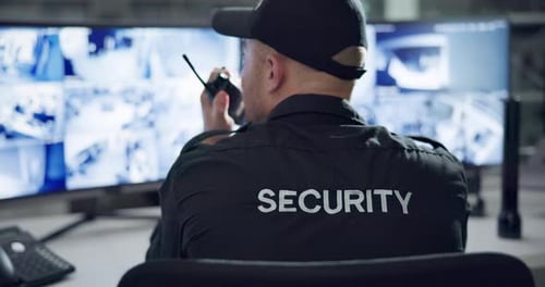 Security Guard Monitoring CCTV Feeds in Control Room