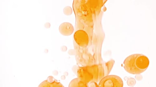 Slow Motion of Moving Yellow Golden Oil Air Bubbles in Water Rising Up on Light White Background
