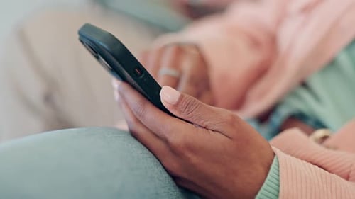 Phone, hands and closeup of woman typing a text message on the internet and relaxing on a sofa