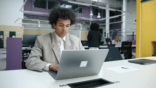 Closeup View of Young Professional in Formal Suit Working on His Laptop