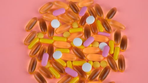Variety of Colorful Pills on Pink Background