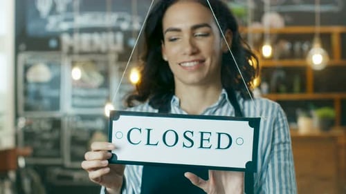 Beautiful Young Cafe Owner Flipping Storefront Sign From Close to Open and Welcoming New Customers