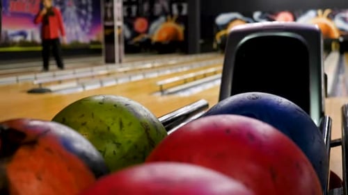 Mann, der in der Bowlingbahn kegelt, wirft Ball die Bahn hinunter