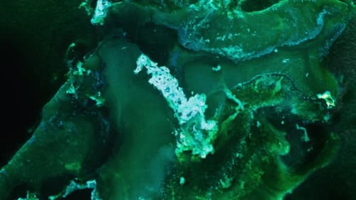 Hypnotic flowing abstract texture of alcohol ink in close-up green tones