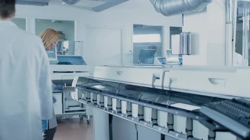 Researcher analyzing sample with computer in laboratory setting