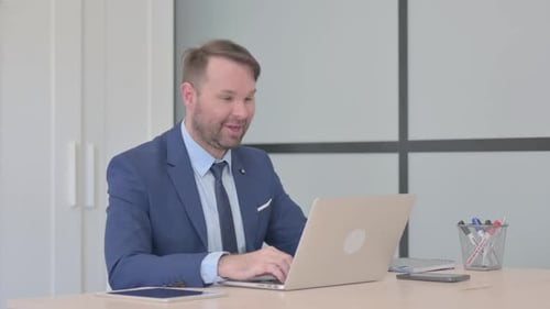 Man in Suit Video Calling at Desk