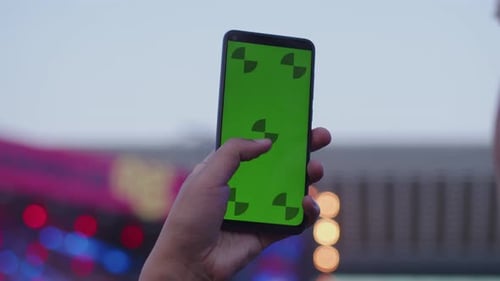 Closeup of a Hand Holding Smart Phone Device with a Green Screen Chromakey Vertically Pressing
