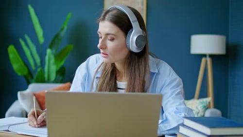 Portrait of Young Girl in Wireless Headphones with Laptop for Webinar Teaching or University Video