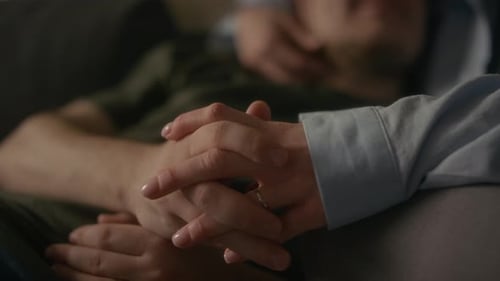 Closeup Couple Holding Hands Cuddling on Couch
