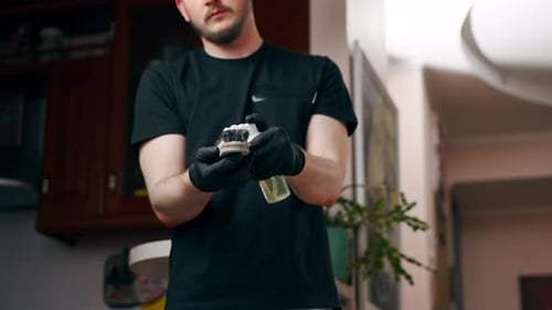 Man Cleaning Light-Colored Couch with Brush and Spray