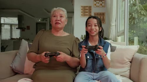 Grandmother and Granddaughter Playing Video Games Together