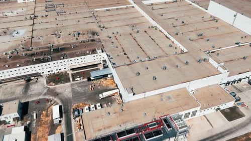 Plain roof of a large plant with numerous pipes on. Flight above the modern factory on sunny day.