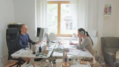 Timelapse of two people working in a bright home office environment