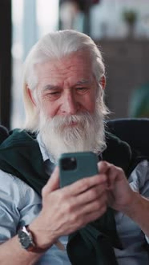 Senior Man with White Hair Using Smartphone