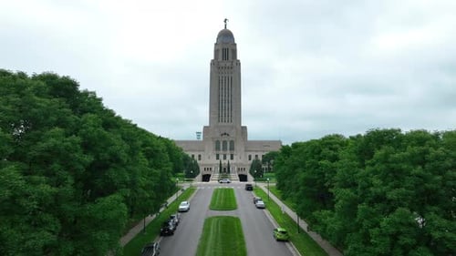 Nebraska's State Capitol building; a tall tower stands above a classical base, surrounded by lush gr