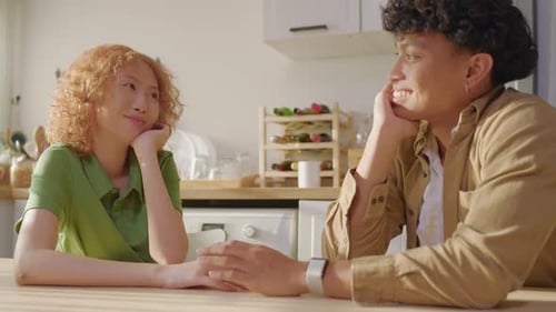 Smiling Couple at Table in Sunny Kitchen