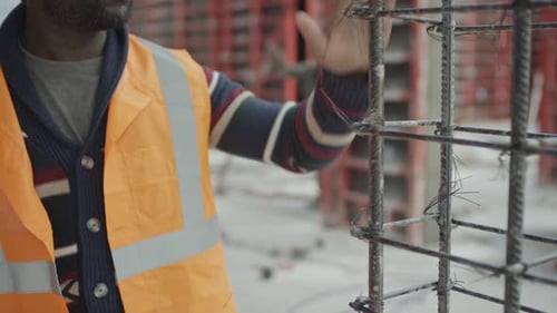 Travailleur noir discutant de problèmes de coffrage sur un chantier de construction