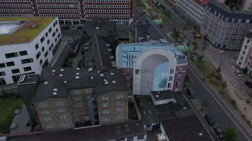 Luftaufnahme von Gebäuden in der Stadt vor dem Himmel bei Sonnenuntergang, Drohne, die rückwärts über die Stadt fliegt