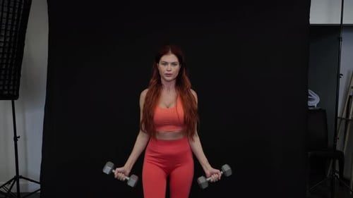 Woman Performs Bicep Curls with Dumbbells for Strength
