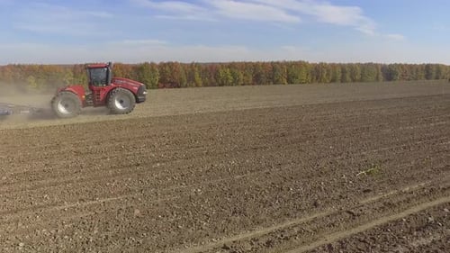 Big red tractor working on the field cultivating and applying nitrogen ASP