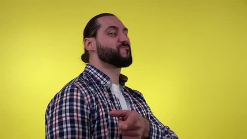 Man Smiles and Points Against a Yellow Background