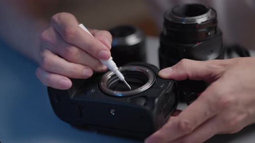 Photographer Hand Cleaning Digital Camera Sensor or Lens Mount Using Specialized Pen Tool Ensuring