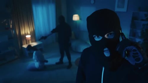 Masked Intruder Taking Call During Home Invasion